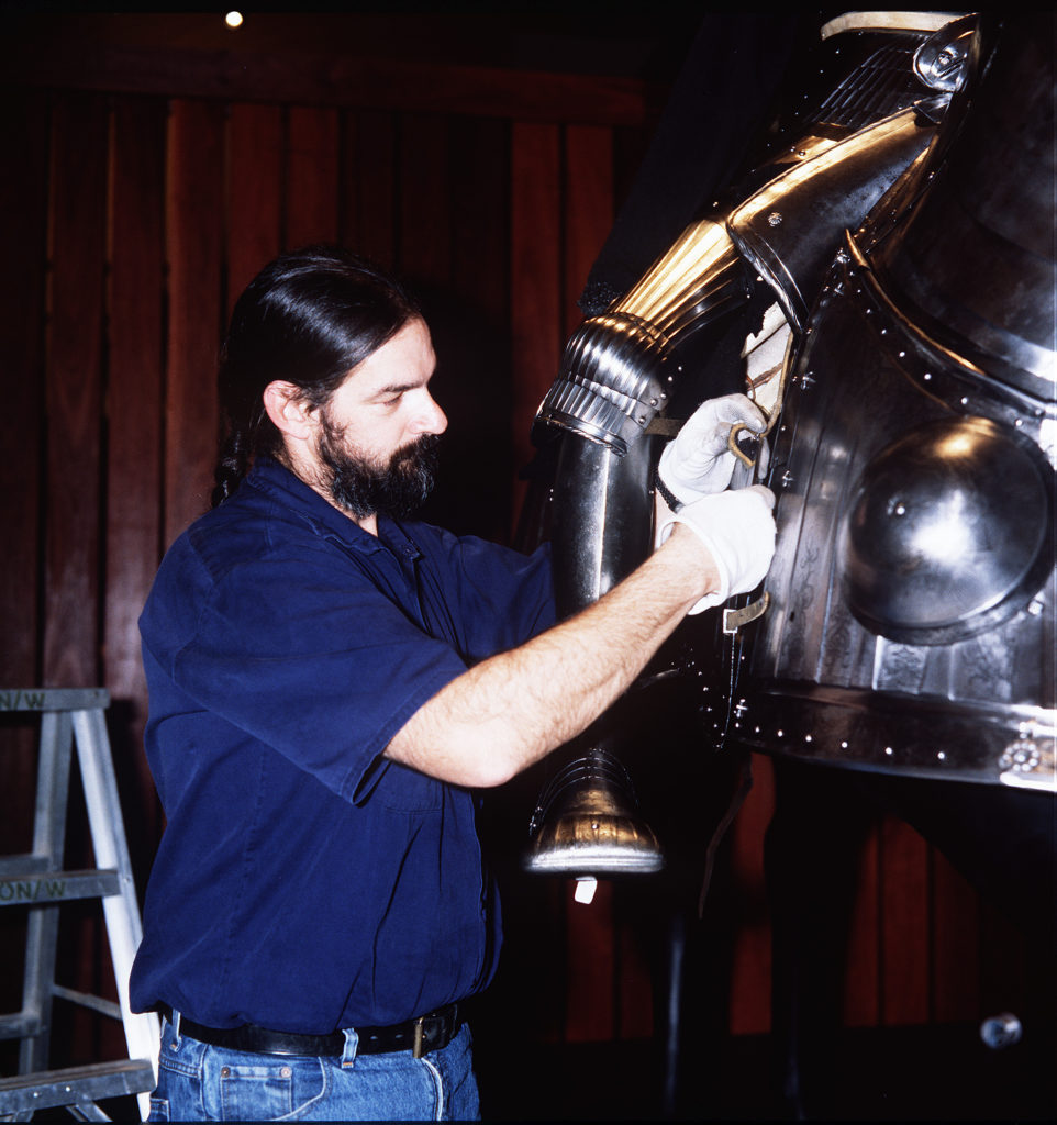 Registrar Cary Ward works on a suit of armour 